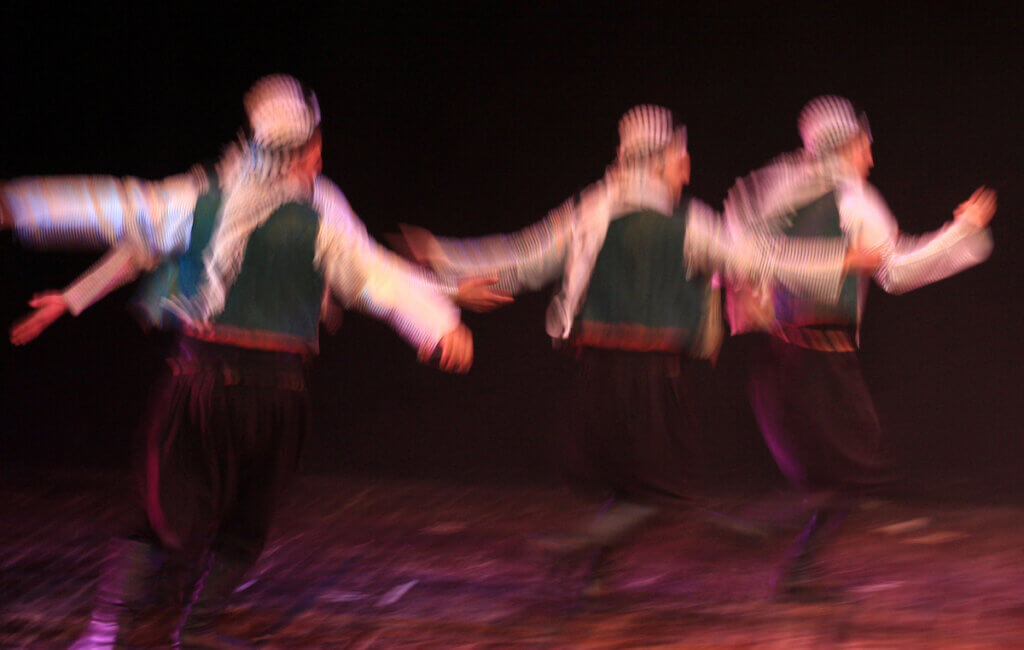 Blurred image of Palestinian actors performing a dance as part of the play, 