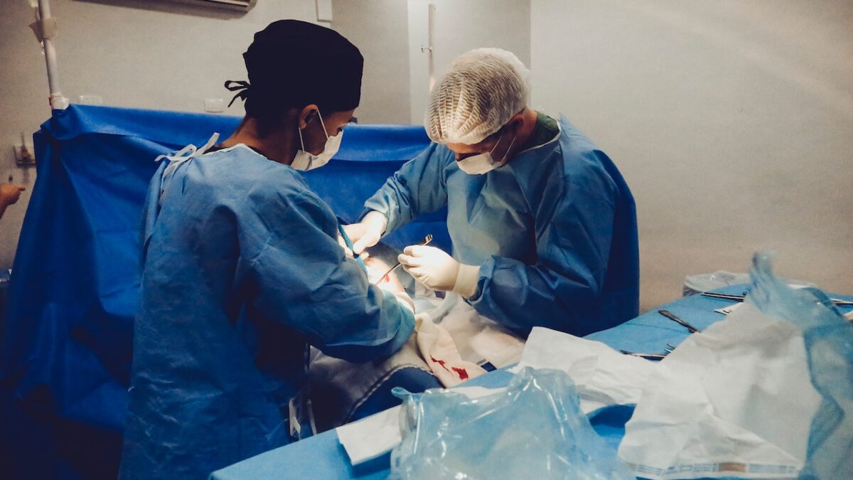 doctors operating on patient in operating room under bright light