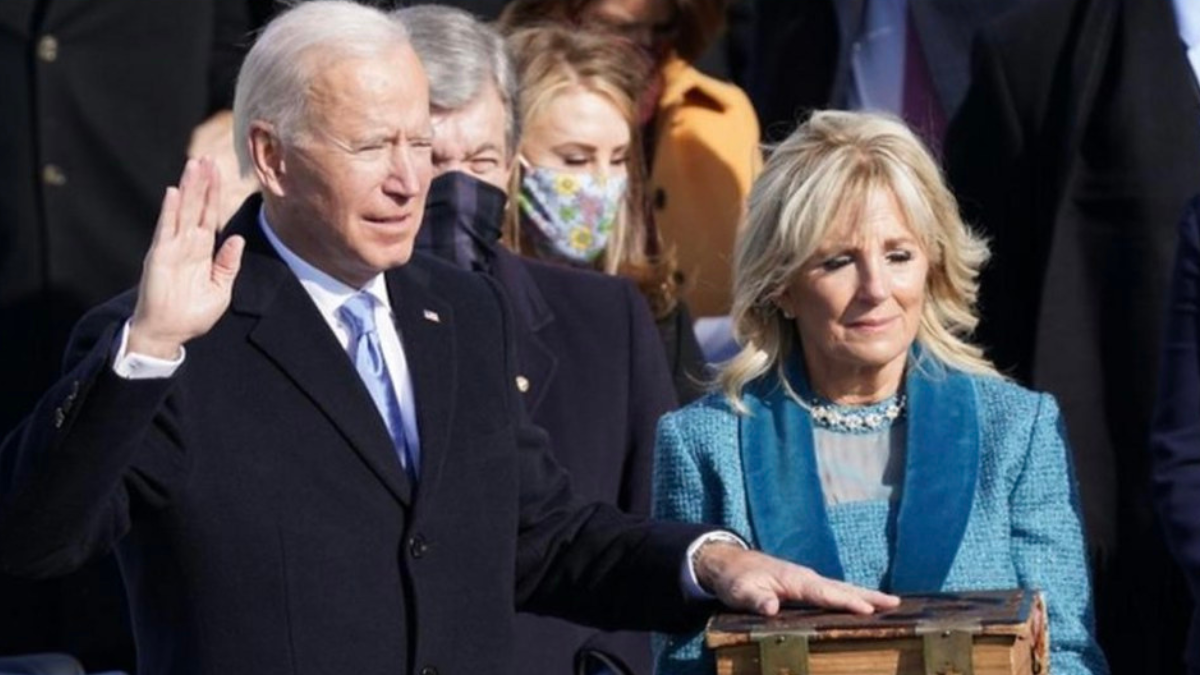 Joe Biden is sworn into presidential office while Jill Biden hold the Bible on which he takes the oath.